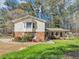 Charming home featuring a brick and vinyl exterior, a manicured lawn, and lovely landscaping at 5221 La Paloma Sw Dr, Lilburn, GA 30047