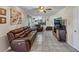 Comfortable living room with a leather sofa set, tile flooring, and view of the stairs and kitchen at 5221 La Paloma Sw Dr, Lilburn, GA 30047