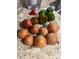 A vibrant display of fresh pomegranates and green bell peppers adorns the kitchen countertop at 5221 La Paloma Sw Dr, Lilburn, GA 30047