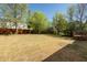 Spacious backyard featuring a lawn, wood fence, mature trees, and a corner deck at 6136 Marbut Rd, Lithonia, GA 30058