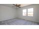 Spacious bedroom featuring soft carpet, a ceiling fan, neutral walls, and two bright windows at 6136 Marbut Rd, Lithonia, GA 30058