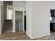 Bright hallway with wood floors leading to an upstairs staircase and a kitchen with sleek, modern, black appliances at 6136 Marbut Rd, Lithonia, GA 30058