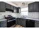 Well-lit kitchen with dark cabinets, stainless steel appliances, granite countertops, and a white subway tile backsplash at 6136 Marbut Rd, Lithonia, GA 30058