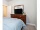Comfortable bedroom with a bed featuring many decorative pillows, and a wooden dresser with a TV at 2320 Ridge View Dr, Loganville, GA 30052