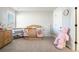 Cozy carpeted bedroom featuring a wooden crib, dresser, and a cute pink teddy bear at 2320 Ridge View Dr, Loganville, GA 30052