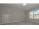 Neutral bedroom with carpet flooring, a window providing natural light, and a closed door at 4850 Cool Springs Rd, Winston, GA 30187