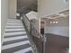 Staircase with decorative iron railing and chandelier, leading to dining room at 4850 Cool Springs Rd, Winston, GA 30187