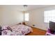 A modest bedroom with hardwood floors, two windows, and a floral patterned bedspread at 1497 Mason Mill Ne Rd, Atlanta, GA 30329