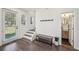 Entry hall with coat rack, stairs, dark wood floors, bench seating, and access to half bathroom at 3087 Alston Dr, Decatur, GA 30032