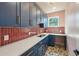 Laundry room features built-in desk, blue cabinets, and decorative backsplash at 3087 Alston Dr, Decatur, GA 30032