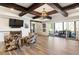 Open basement area with wood beams, stylish furniture, a fireplace, and an outdoor patio at 230 Hardscrabble Rd, Roswell, GA 30075