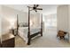 Bright bedroom featuring a four-poster bed, a ceiling fan, and shuttered windows for light control at 230 Hardscrabble Rd, Roswell, GA 30075