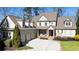 Charming two-story home with a three-car garage, manicured lawn, and covered front porch at 230 Hardscrabble Rd, Roswell, GA 30075
