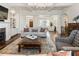 Bright and open living room showcasing hardwood floors, coffered ceilings, and a fireplace at 230 Hardscrabble Rd, Roswell, GA 30075
