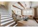 Inviting living room showcasing hardwood floors, wood beam accents, and a large window with a comfortable sofa at 230 Hardscrabble Rd, Roswell, GA 30075