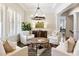 Bright and airy living room with white armchairs, a wooden table, and large windows with plantation shutters at 230 Hardscrabble Rd, Roswell, GA 30075