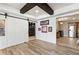 Relaxing living space with a barn door, wooden beams, hardwood floors, and mini bar at 230 Hardscrabble Rd, Roswell, GA 30075