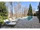 Lounge chairs sit by an in-ground pool and spa in this well-landscaped backyard at 230 Hardscrabble Rd, Roswell, GA 30075
