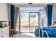Bedroom featuring blue drapes, wood floors, and sliding glass door to a patio with seating at 2479 Peachtree Ne Rd # 104, Atlanta, GA 30305