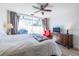 Bright bedroom boasts a ceiling fan, wood floors, sliding door to outdoor patio, and a dresser with a TV at 2479 Peachtree Ne Rd # 104, Atlanta, GA 30305