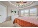 Primary bedroom with tray ceilings and a dresser next to large windows at 3030 Westpoint Cir, Snellville, GA 30078
