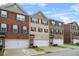 A row of townhomes with brick and siding exteriors, showcasing individual garage spaces and well-maintained landscaping at 3030 Westpoint Cir, Snellville, GA 30078