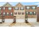 Charming townhomes featuring a brick facade, symmetrical windows, and attached garages for convenient parking at 3030 Westpoint Cir, Snellville, GA 30078