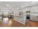 Kitchen with stainless steel appliances and a large island, open to the dining and living areas at 3030 Westpoint Cir, Snellville, GA 30078