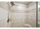 Close-up of the shower, which features white tile and decorative accent pieces at 3030 Westpoint Cir, Snellville, GA 30078