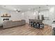 Open concept living area features wood floors, fireplace, and breakfast bar with modern pendant lighting at 3040 Westgate Park Dr, Loganville, GA 30052