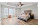 Bright main bedroom features a tray ceiling, neutral decor, and large windows for natural light at 3040 Westgate Park Dr, Loganville, GA 30052