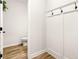 Mudroom with hooks and view into half bath with wood-look flooring at 3040 Westgate Park Dr, Loganville, GA 30052