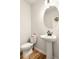 Well-lit half bathroom with pedestal sink, oval mirror, and stylish fixtures at 3040 Westgate Park Dr, Loganville, GA 30052