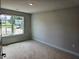 Another bedroom featuring a window with neighborhood views and neutral walls at 305 Melanie Ct, Bowdon, GA 30108