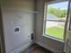 Functional laundry room with hookups, shelving and a window providing natural light at 305 Melanie Ct, Bowdon, GA 30108