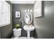 Stylish powder room with a pedestal sink, decorative mirror, and modern lighting at 1011 Dogwood Forest Ne Dr, Marietta, GA 30068