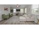 Comfortable living room featuring a sectional sofa, green armchairs, and a large rug in a well-lit, inviting space at 2960 Fareed St, Douglasville, GA 30135