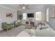 Stylish living room with a comfortable sofa, green armchairs, and large windows providing ample natural light at 2960 Fareed St, Douglasville, GA 30135
