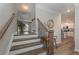 Staircase with stained wood steps, wrought iron spindles, and a view into the kitchen at 2960 Fareed St, Douglasville, GA 30135