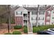 Exterior view of brick and vinyl apartment building with stairs and mature landscaping at 330 Teal Ct, Roswell, GA 30076