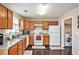 Practical kitchen design with wooden cabinets, efficient appliances, and adjacent laundry area at 744 Mesa Rd, Mcdonough, GA 30253