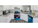 Modern kitchen featuring sleek white cabinets, granite countertops, and a blue accented range and dishwasher at 155 Hitchcock Dr, Villa Rica, GA 30180
