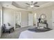 The main bedroom has a tray ceiling with fan, carpet, a chair, and an entry to a bathroom at 155 Hitchcock Dr, Villa Rica, GA 30180