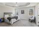 The main bedroom has a tray ceiling with fan, carpet, two windows, and a chair at 155 Hitchcock Dr, Villa Rica, GA 30180