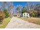 Quaint home with gray garage door and a cheerful blue front door and large cracked driveway at 2330 Regal Ct, Lawrenceville, GA 30044