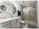 Modern bathroom with a vanity, round mirror, sleek fixtures, and a glass-enclosed shower at 1080 Peachtree Ne St # 1909, Atlanta, GA 30309