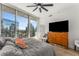 A bright bedroom featuring a ceiling fan, light wood floors, and access to balcony with cityscape view at 1080 Peachtree Ne St # 1909, Atlanta, GA 30309