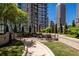 Outdoor seating area with tables and umbrellas, surrounded by trees and landscaping at 1080 Peachtree Ne St # 1909, Atlanta, GA 30309
