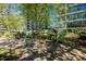 Scenic outdoor seating area with green Adirondack chairs on stone pavers, surrounded by greenery at 1080 Peachtree Ne St # 1909, Atlanta, GA 30309