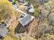 Aerial view showcasing a modern home with spacious driveway, decks, and surrounded by mature trees at 122 S Mill Creek Ct, Woodstock, GA 30188